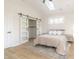 Inviting bedroom with vaulted ceiling, sky light, barn door closet, and wood-look flooring at 1124 Upchurch St, Raleigh, NC 27610