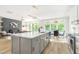Open floor plan with kitchen island and adjoining dining and living areas at 1124 Upchurch St, Raleigh, NC 27610