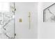 Walk-in shower with gold hardware, marble accent wall, and white honeycomb tile at 1124 Upchurch St, Raleigh, NC 27610