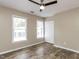 This bedroom features a ceiling fan, wood-look floors, two windows and a closet at 113 Weatherstone Dr # B, Chapel Hill, NC 27514