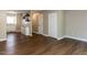Spacious room featuring wood flooring and neutral walls, leading to an open kitchen area at 113 Weatherstone Dr # B, Chapel Hill, NC 27514