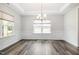 Elegant dining room with wainscoting, a tray ceiling, and modern chandelier at `120 Red Hawk Pl, Smithfield, NC 27577