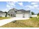 Beautiful two-story home with a manicured lawn, a three-car garage, and a charming stone porch at `120 Red Hawk Pl, Smithfield, NC 27577