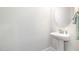 Chic half-bathroom featuring a pedestal sink, an oval mirror, and modern fixtures at `120 Red Hawk Pl, Smithfield, NC 27577