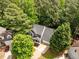 Aerial view of a charming home with a well-manicured lawn, mature trees, and a spacious driveway in a suburban neighborhood at 1204 Benoit Pl, Apex, NC 27502