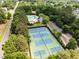 Aerial view of community amenities including a pool, sports courts, clubhouse, parking, and surrounding trees at 1204 Benoit Pl, Apex, NC 27502