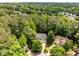Aerial view of a home nestled among mature trees, showcasing its landscaped yard and neighborhood setting at 1204 Benoit Pl, Apex, NC 27502