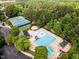 Aerial view of community pool, sports courts, and clubhouse nestled within a lush, green landscape at 1204 Benoit Pl, Apex, NC 27502
