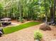 Backyard with deck, artificial turf, and wooded area, great for outdoor activities at 1204 Benoit Pl, Apex, NC 27502