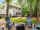 Backyard with fire pit, patio, lawn, and wooded area, ideal for relaxation and gatherings at 1204 Benoit Pl, Apex, NC 27502