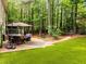 Landscaped backyard with a covered patio and outdoor seating, perfect for enjoying nature at 1204 Benoit Pl, Apex, NC 27502