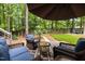 Backyard patio area with umbrella and seating, surrounded by mature trees at 1204 Benoit Pl, Apex, NC 27502