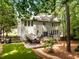 Beautiful backyard featuring a deck, patio seating, mature trees, and landscaping, perfect for outdoor entertaining at 1204 Benoit Pl, Apex, NC 27502