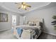 Comfortable bedroom with trey ceiling, ceiling fan, and a cozy bed with throw blanket and decorative pillows at 1204 Benoit Pl, Apex, NC 27502