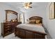 Comfortable bedroom featuring dark wood furniture and a lighted ceiling fan at 1204 Benoit Pl, Apex, NC 27502