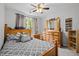 Cozy bedroom with ceiling fan, wooden furniture set, patterned bedding, and natural light from the window at 1204 Benoit Pl, Apex, NC 27502