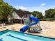 Community pool with slide next to the clubhouse and lounge chairs for relaxing poolside at 1204 Benoit Pl, Apex, NC 27502