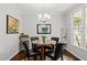 Cozy dining area with a round table, comfortable chairs, elegant lighting, and a view of the outdoors at 1204 Benoit Pl, Apex, NC 27502