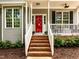 Close-up of front porch with brick steps, white railings, a bright red door, and inviting curb appeal at 1204 Benoit Pl, Apex, NC 27502