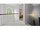 Upstairs hallway featuring a window and doorway leading into a carpeted bedroom with ceiling fan at 1204 Benoit Pl, Apex, NC 27502
