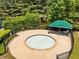 Community hot tub with gazebo, fence, and chairs surrounded by trees and landscaping at 1204 Benoit Pl, Apex, NC 27502