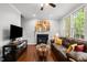 Comfortable living room with a fireplace, a large sofa, wood floors, and plenty of natural light at 1204 Benoit Pl, Apex, NC 27502