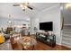 Inviting living room with hardwood floors, ceiling fan, and staircase access at 1204 Benoit Pl, Apex, NC 27502