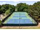 Aerial view of the community sports courts, including tennis courts and basketball courts, surrounded by trees at 1204 Benoit Pl, Apex, NC 27502