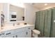 Bright bathroom features a white vanity with framed mirror, green shower curtain, and tiled flooring at 1223 Brown Velvet Ln, Apex, NC 27523