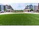 Central common area with two pavilion structures, grassy open space and townhome-style buildings in background at 1223 Brown Velvet Ln, Apex, NC 27523