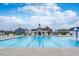 Large community pool with lounge chairs, covered picnic area, and splash pad underneath a bright cloudy sky at 1223 Brown Velvet Ln, Apex, NC 27523