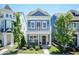 Charming two-story blue home with a welcoming front porch, landscaped yard and second story porch at 1223 Brown Velvet Ln, Apex, NC 27523