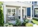Cozy front porch with seating, potted plants, and a charming entrance to a inviting home at 1223 Brown Velvet Ln, Apex, NC 27523