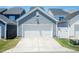 Two car garage with white door and concrete driveway in a community of homes at 1223 Brown Velvet Ln, Apex, NC 27523