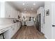 Spacious kitchen featuring white cabinets, stainless steel appliances, and wood grain flooring at 1223 Brown Velvet Ln, Apex, NC 27523