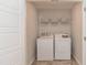 Well-lit laundry room with washer and dryer, shelving, and neutral walls at 1223 Brown Velvet Ln, Apex, NC 27523