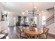 Open-concept living room with wood floors, modern lighting, and a staircase to the upper level at 1223 Brown Velvet Ln, Apex, NC 27523
