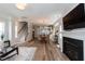 Open-concept living room with hardwood floors, fireplace, and view of the dining and kitchen area at 1223 Brown Velvet Ln, Apex, NC 27523