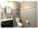 Stylish powder room featuring wainscoting, black vanity, and a round mirror at 1223 Brown Velvet Ln, Apex, NC 27523