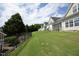 View of well-maintained lawn sloping down from a row of homes with screened-in porches, fenced for privacy at 12306 Mossgreen St, Raleigh, NC 27614