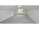 A spacious carpeted bedroom with a window and ceiling fan provides a light and airy space at 12306 Mossgreen St, Raleigh, NC 27614