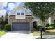 Charming home showcasing a stone facade, gray garage door, and manicured landscaping in a serene setting at 12306 Mossgreen St, Raleigh, NC 27614