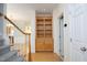 Hallway with hardwood floors and built-in shelving unit near stairs at 12306 Mossgreen St, Raleigh, NC 27614