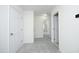 Hallway with neutral colored walls, multiple doors, and carpeted floor, creating a bright transition space at 12306 Mossgreen St, Raleigh, NC 27614