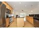 Kitchen with stainless steel appliances, dark granite countertops and adjoining living room with fireplace at 12306 Mossgreen St, Raleigh, NC 27614