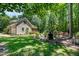Spacious backyard with a stone patio area, mature trees, and wooded surroundings at 12733 Pamplona Dr, Wake Forest, NC 27587
