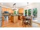 Eat-in kitchen with stainless steel appliances, wood cabinetry, and a breakfast table near the windows at 12733 Pamplona Dr, Wake Forest, NC 27587