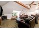 Spacious living room with leather seating, fireplace, wet bar, exposed beams, and natural light at 12733 Pamplona Dr, Wake Forest, NC 27587