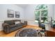 Cozy living room with ample natural light, a comfortable sofa, and a spacious desk area near a large window at 12733 Pamplona Dr, Wake Forest, NC 27587