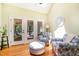 Bright living room with hardwood floors, ceiling fan, and seating area near glass doors leading to a screened porch at 12733 Pamplona Dr, Wake Forest, NC 27587